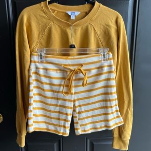 Mustard yellow cropped crew neck sweatshirt with matching cotton striped shorts.